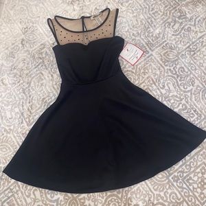 Black baby doll dress with nude mesh neck line and black studs.